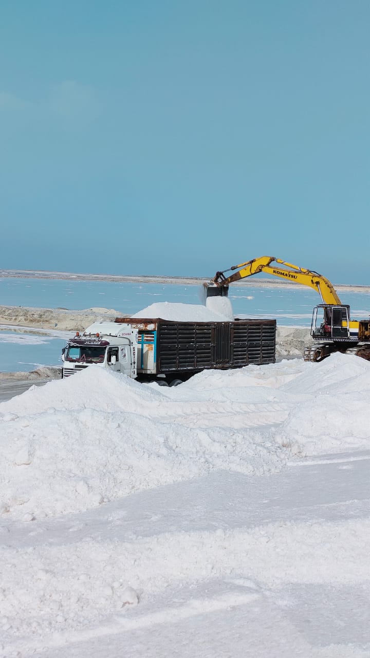 Excavator loading salt truck